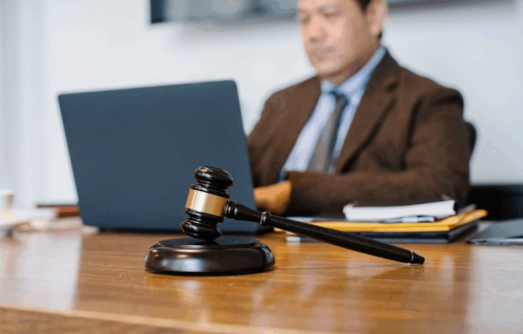 Judge’s gavel on desk with person researching how to handle a small claims court case