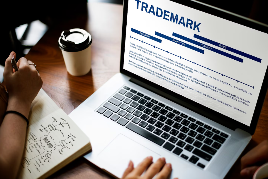 Entrepreneur researching how to trademark a small business name and logo on laptop