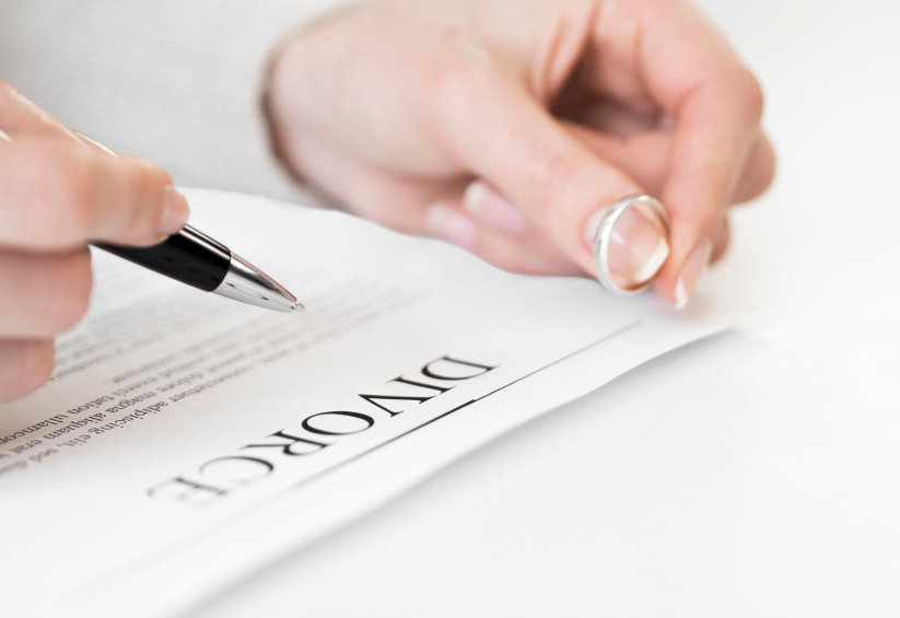 Person signing divorce papers as part of a legal name change process.