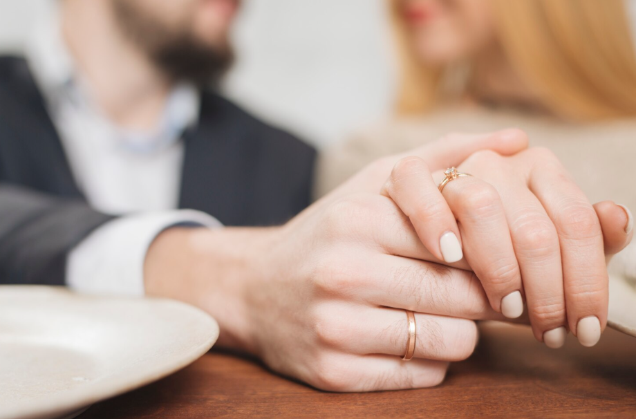 Married couple showing wedding rings while discussing prenuptial and postnuptial agreements.