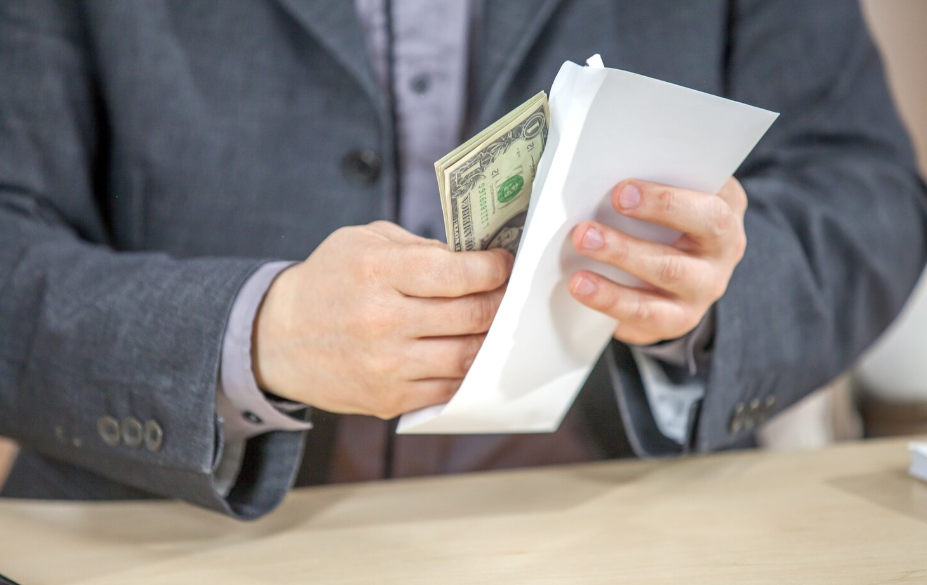 Person counting cash payment after company closure to recover owed wages