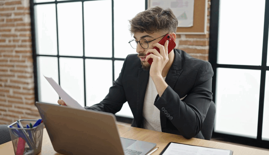 Man on phone reviewing a debt collection notice at his desk